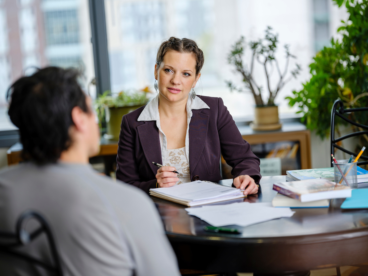 Image of individual in business casual attire meeting with student.