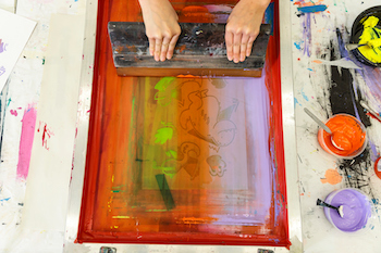 overhead view of a student creating a multi-colored screen print