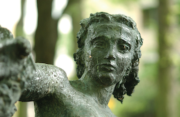 close up photo of a bronze statue in the PSU Park Blocks. Photo is of the statues face. 