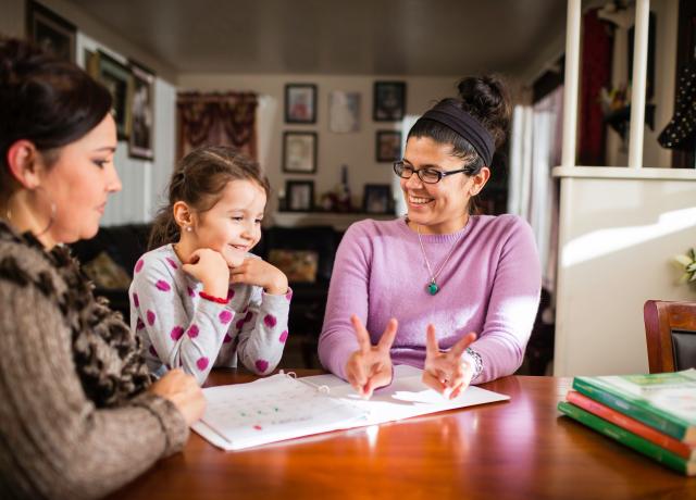 teacher and child seated t a table