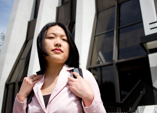 Asian woman in a suit coat standing outside the Portland Wells Fargo tower