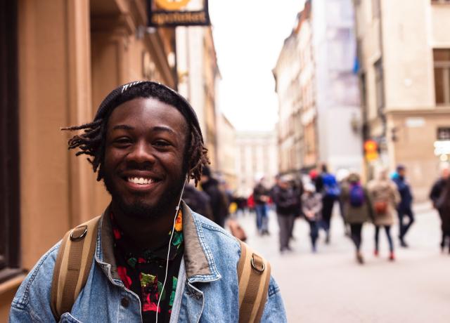 a black youth stands on a city street