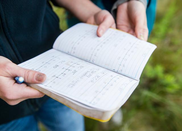 a closeup of a student holding an open notebook