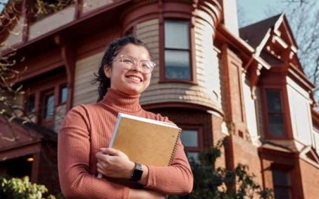 Student smiling in front of Honors House