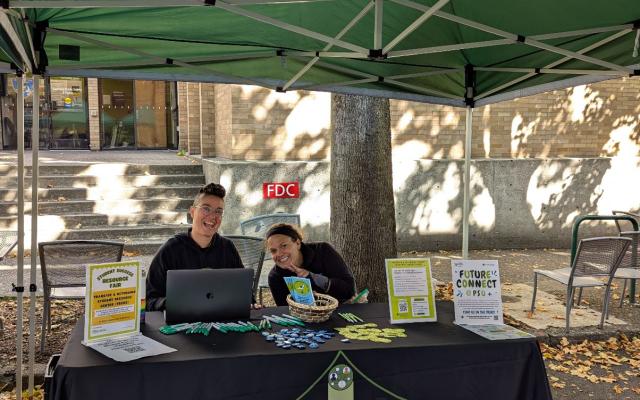 Image of two advisors sitting outside at resource fair.