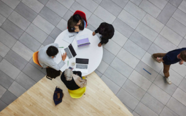 Image of students around their laptops.