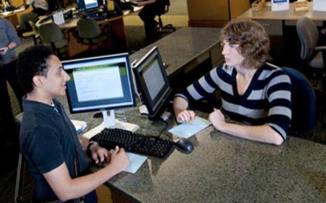 Image of libarian helping a student.