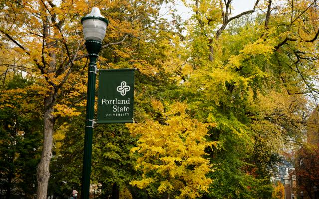 trees in autumn with lam post and PSU sign in foreground