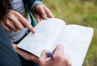 detail of notebook with pointing finger