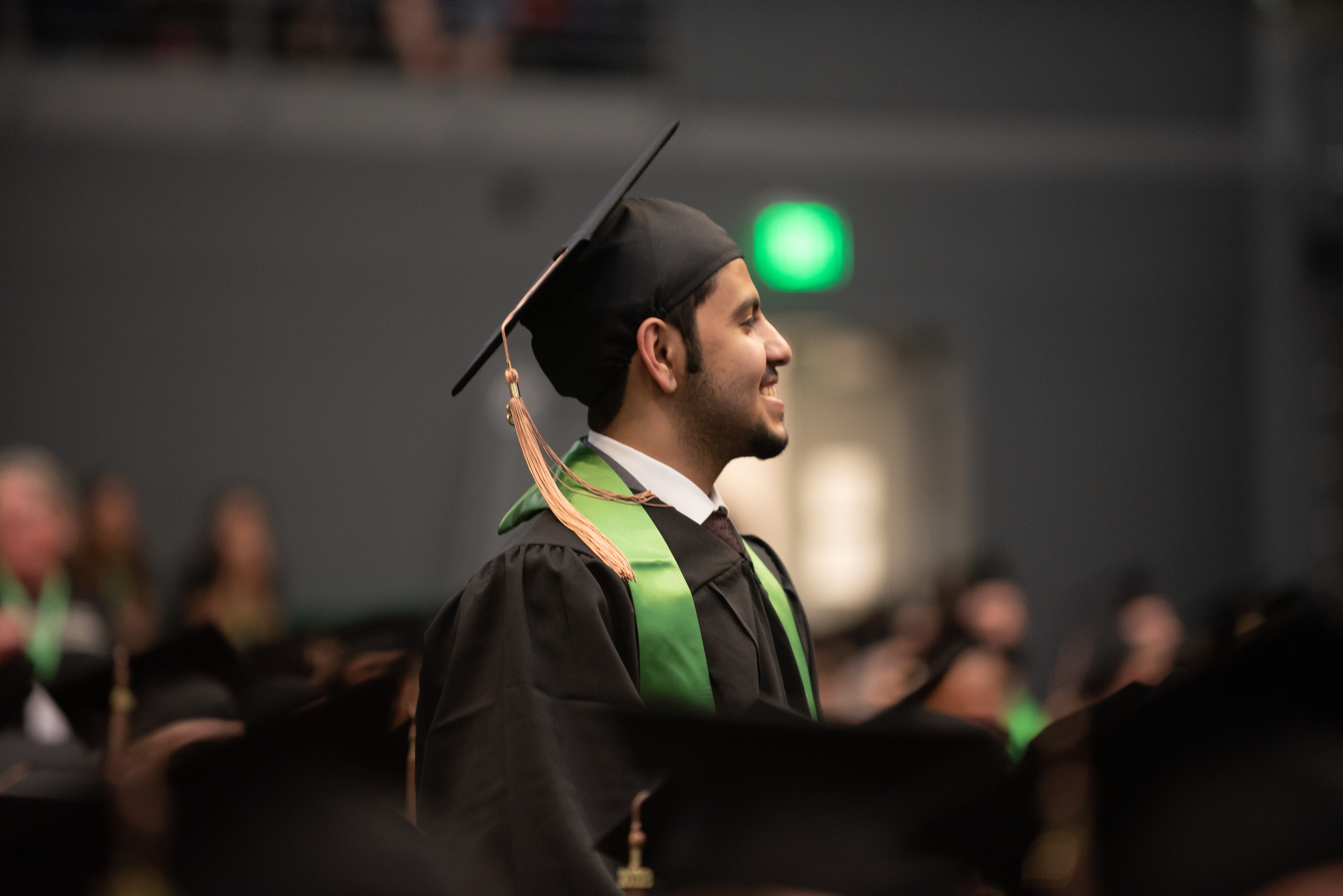 Student in graduation cap smiling.