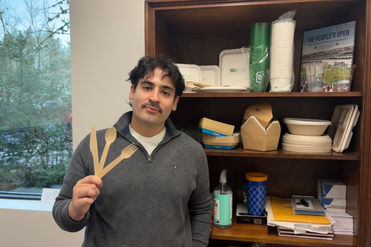 Hunter holding utensils in front of a shelving unit