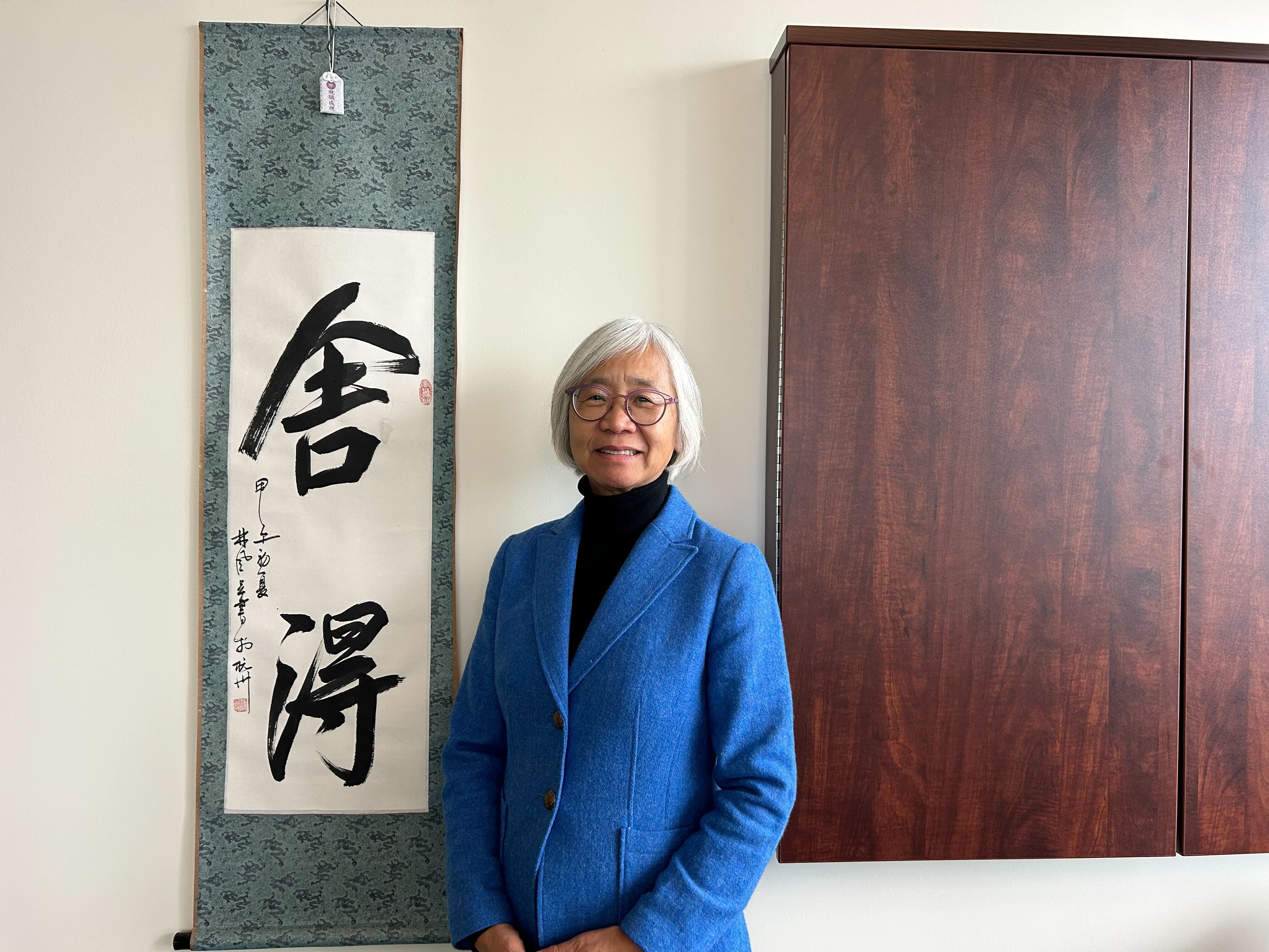 Dean Wong with favorite painting in her office