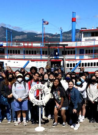 TRIO Upward Bound students alongside a river paddle wheeler boat.