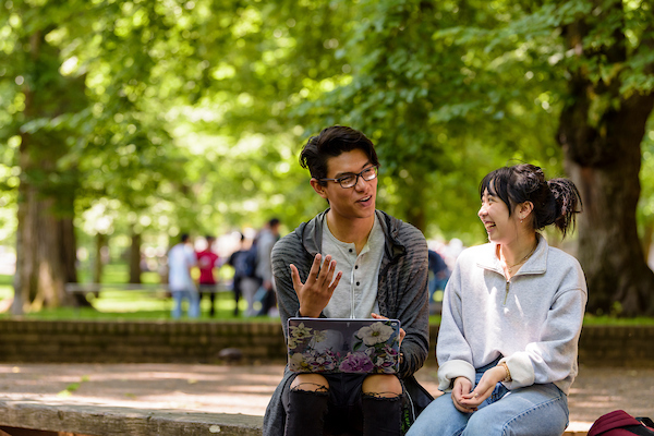 2 Students looking at laptop. 