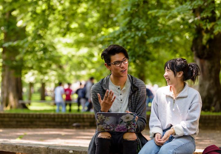 2 Students looking at laptop. 