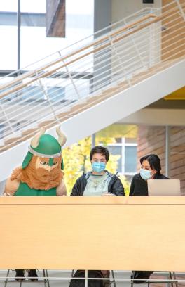 the viking mascot with two students