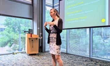 Junia Howell stands in front of a projection screen as she gives her presentation.