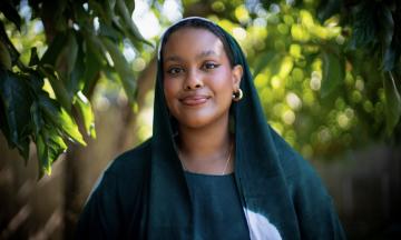 Ahlam Osman stands by a persimmon tree at her home in Northeast Portland.