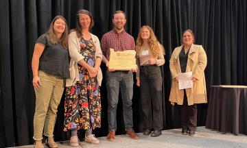 Members of Revive Planning Group stand with their award and the award presenter