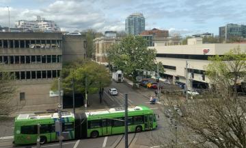 An intersection in Portland, Oregon. A green city bus is crossing the intersection.