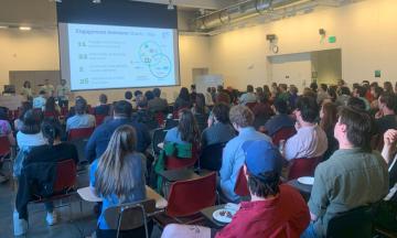 At the front of the room, Maura Paxton, Andrew Azar, and Diego Joao Murphy-Mendez present their project