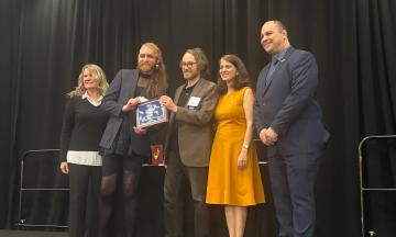  MURP students Alex Gill and Eric Gasper (second and third from left) accepting the CUTC award in Washington, DC on January 10th, 2026.
