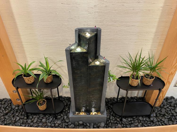 three tiered fountain, shelves on either side with plants on them