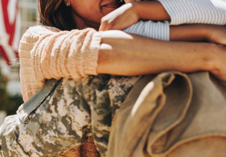 Woman hugging someone in military uniform