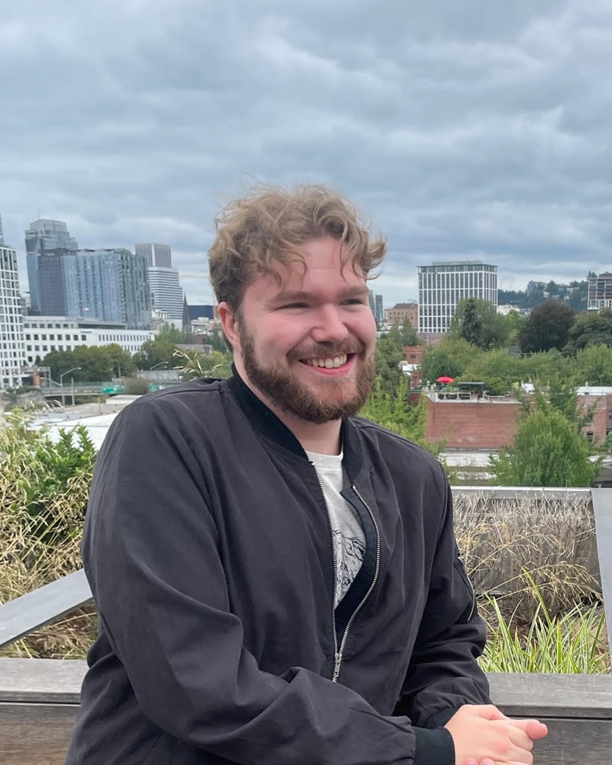 grad student on a balcony smiling