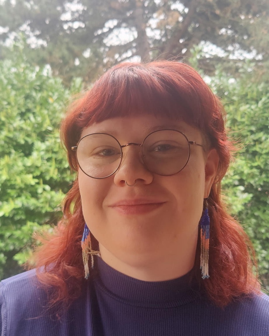 grad student with glasses and earrings outside