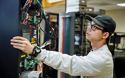 Student in an engineering lab working on a computer server 