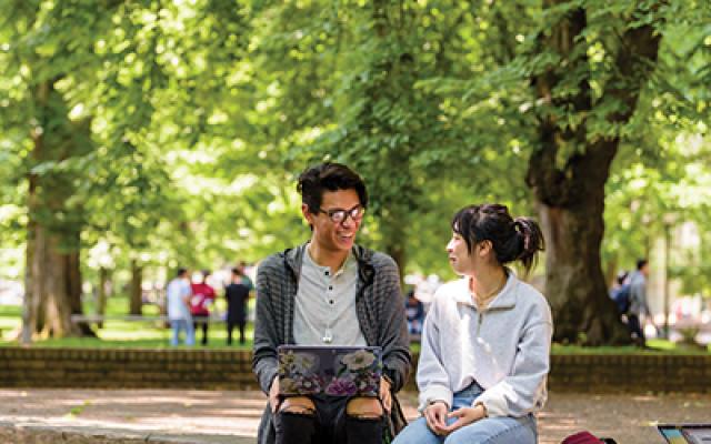 Two students on a laptop in the park blocks