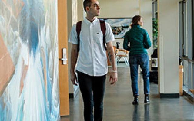 Student walking through the hall in the School of Social Work