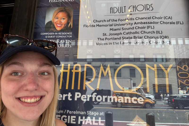 Student in front of Carnegie Hall poster with pic of Coty visible 