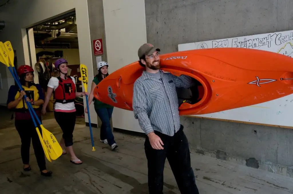 Students taking kayaks from outdoor program
