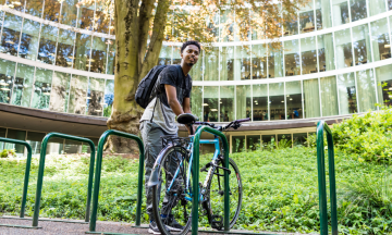 Cyclist parking bike outside of PSU library 