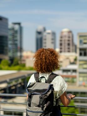 Back of woman with backpack looking at city