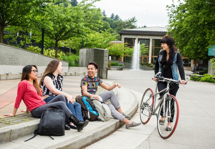 Four students sitting on the steps of the Walk of the Heroines