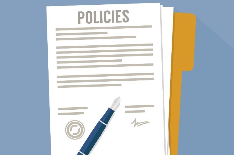 An image of a pen and policies pages on a file folder