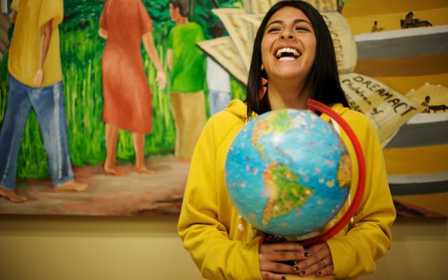 PSU world language pedagogy undergraduate student holding world globe