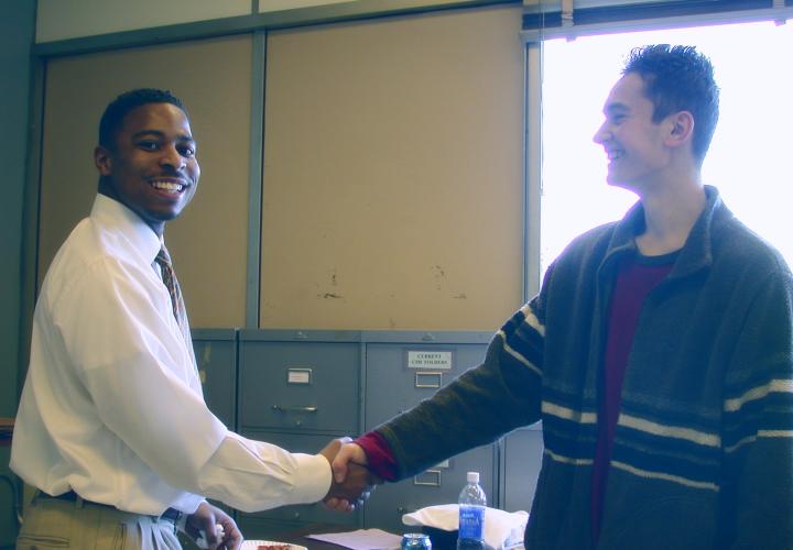 Mentor shaking hands with teen